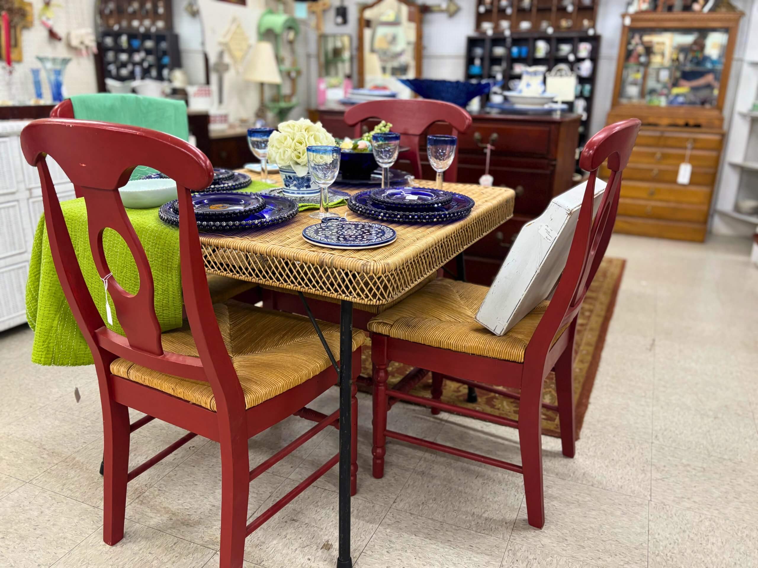 Red wooden dining set with wicker seats and vintage blue dishware at Elmwood Antique Centre in Abilene, TX