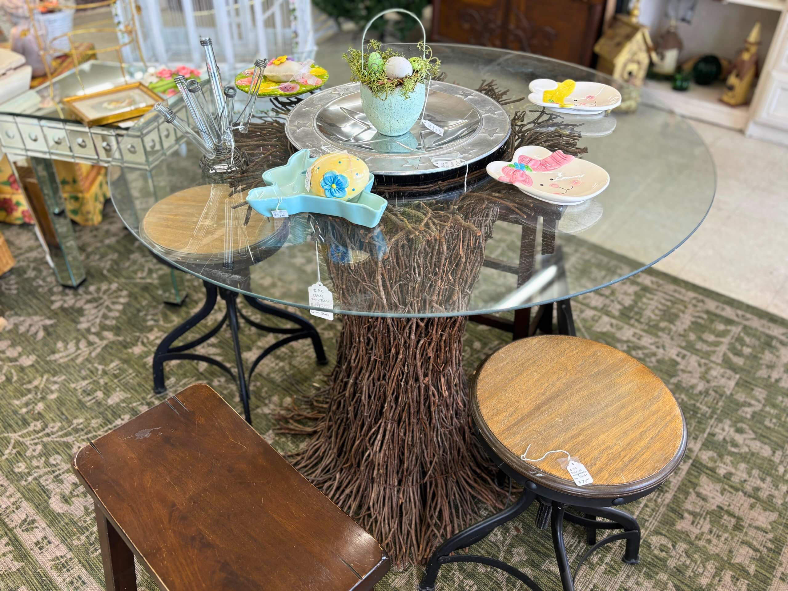 Rustic glass-top table with twig base and wooden stools on display at Elmwood Antique Centre in Abilene, TX