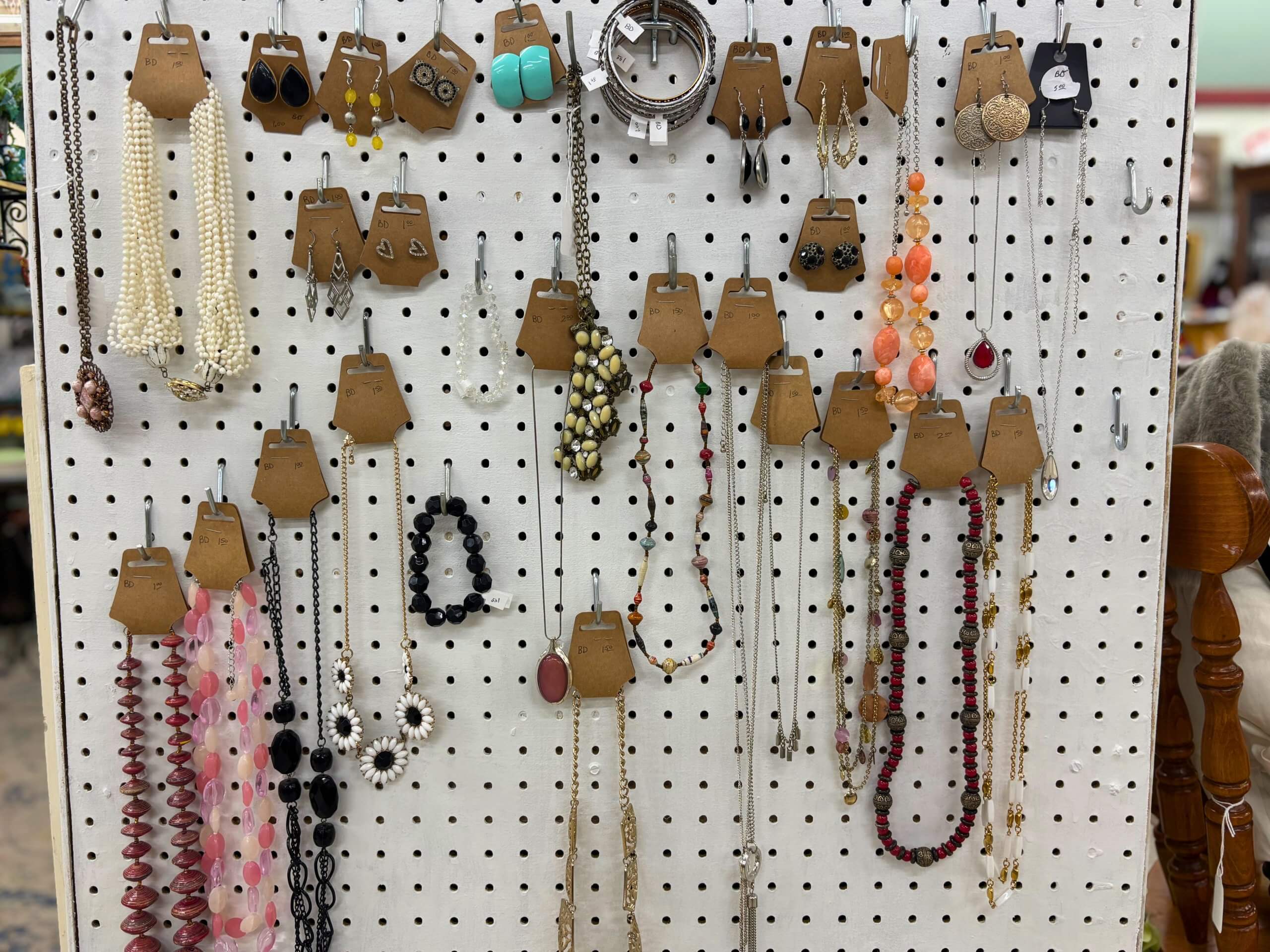 Pegboard display of vintage necklaces, earrings, and bracelets at Elmwood Antique Centre in Abilene, TX